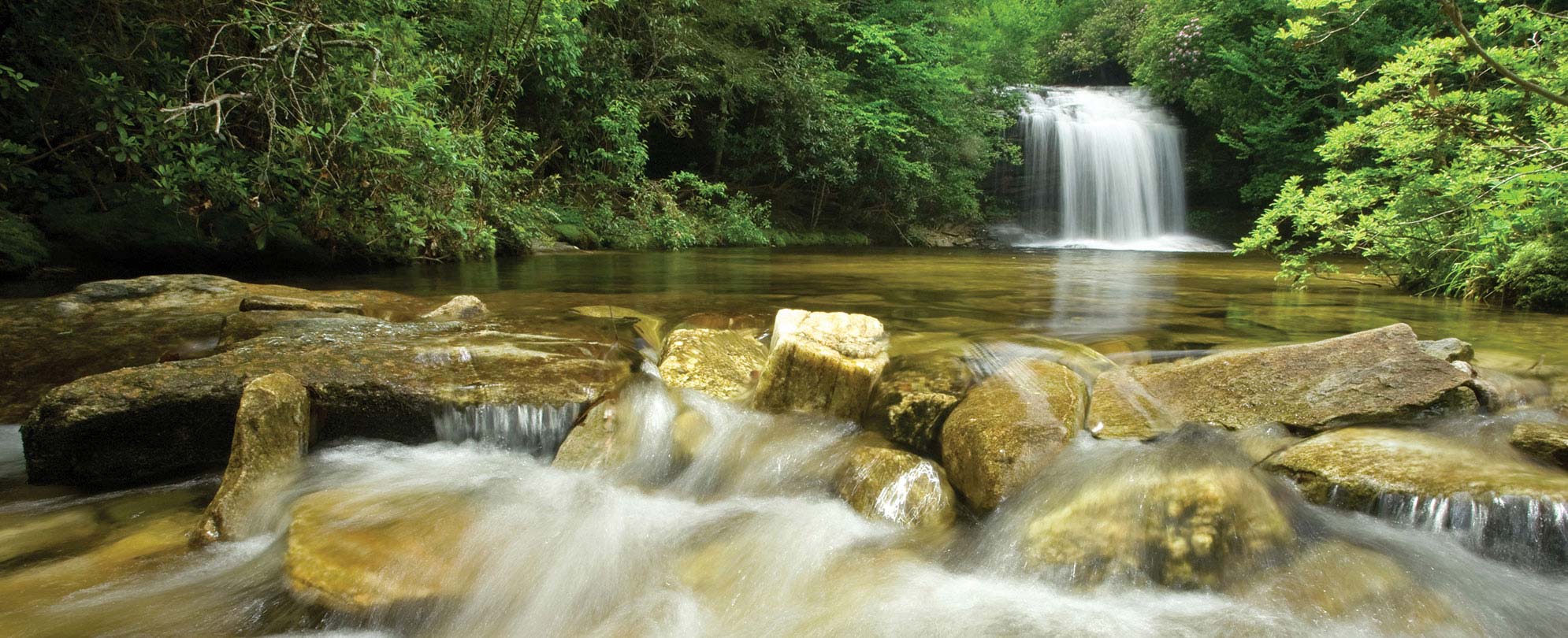 A waterfall streams through the river rocks on a national park vacation