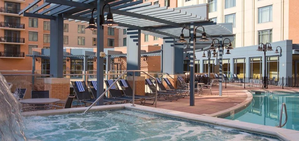 Jetted hot tub and pool chairs under an awning at a Margaritaville Vacation Club resort pool.