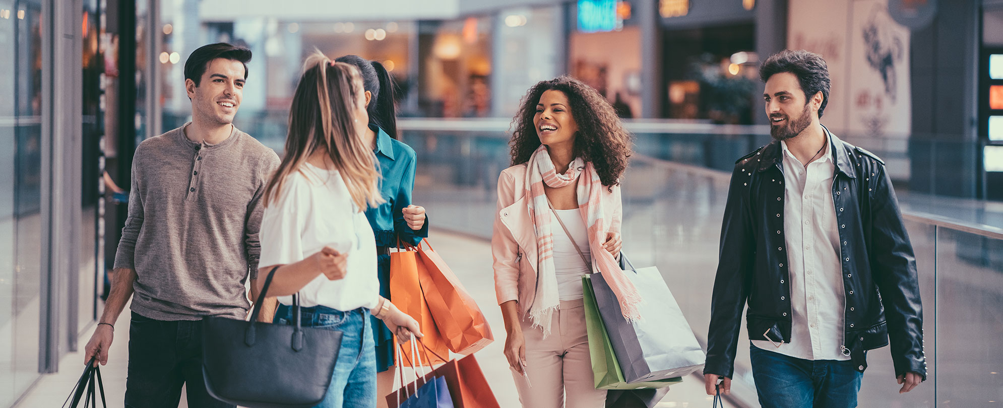 Men and women carrying shopping bags walk and talk as they shop near their Margaritaville Vacation Club resort in Las Vegas.