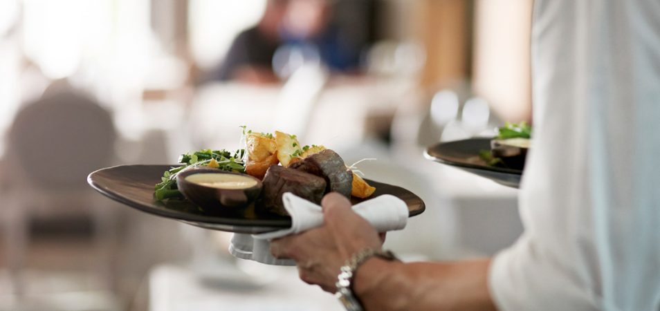 A server carries out two plates of food at one of the top places to eat in St. Thomas, U.S. Virgin Islands.