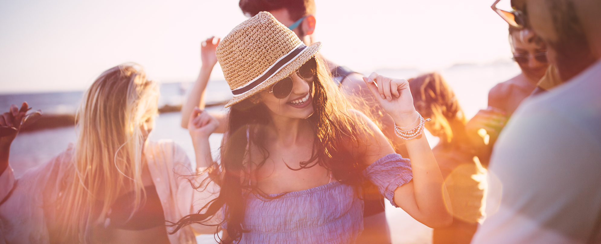 Men and woman dancing on the beach at sunset, swaying to the beat of music therapy at a Margaritaville Vacation Club resort.