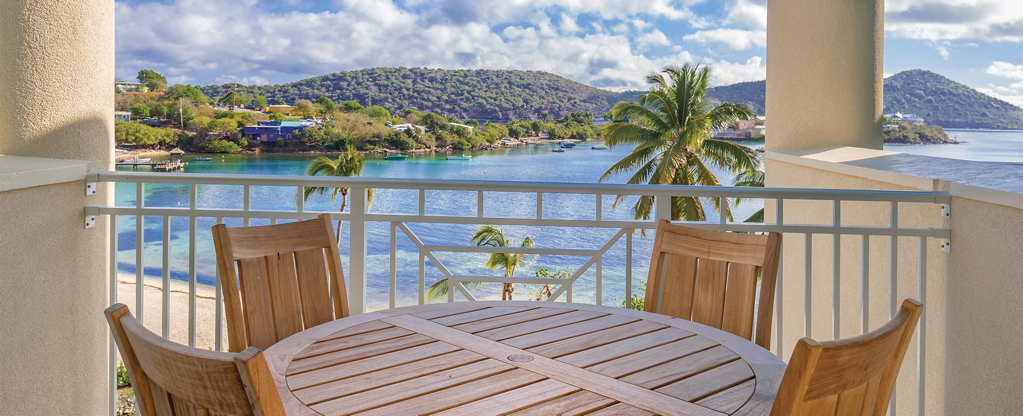 Wood table on an oceanfront balcony in a Presidential Reserve suite at Margaritaville Vacation Club by Wyndham - St. Thomas.