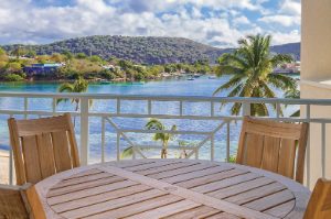 Wood table on an oceanfront balcony in a Presidential Reserve suite at Margaritaville Vacation Club by Wyndham - St. Thomas.