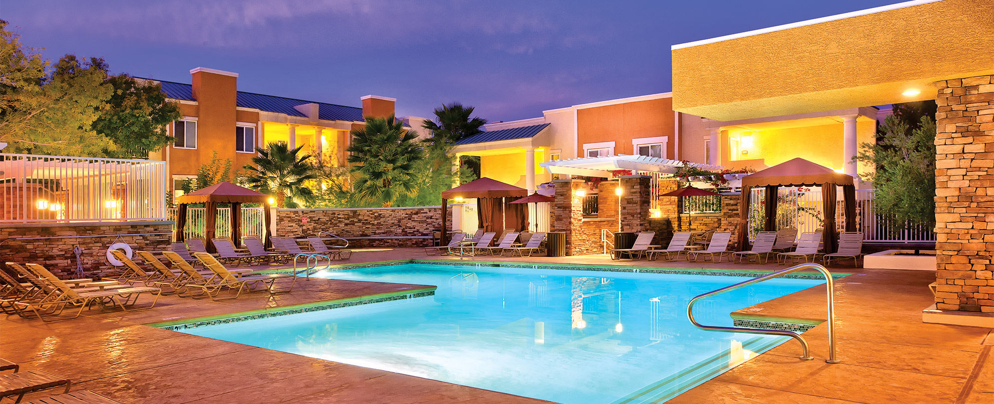 The outdoor pool of WorldMark Tropicana surrounded by sun loungers and cabanas.